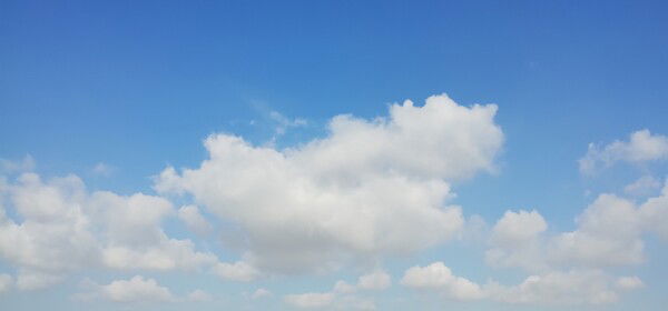 Fluffly white clouds in a blue sky.