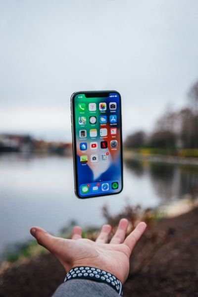 An iPhone floating in the air above someone’s open hand
