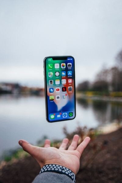 An iPhone floating in the air above someone's open hand