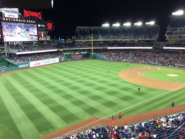 Nats game at Nationals Park in Washington, DC. It is after sunset, the field is fresh and green with a criss-cross pattern. The stands are full. The marquees are lit. The lighting is bright. Play ball!

Photo date: April 22, 2015