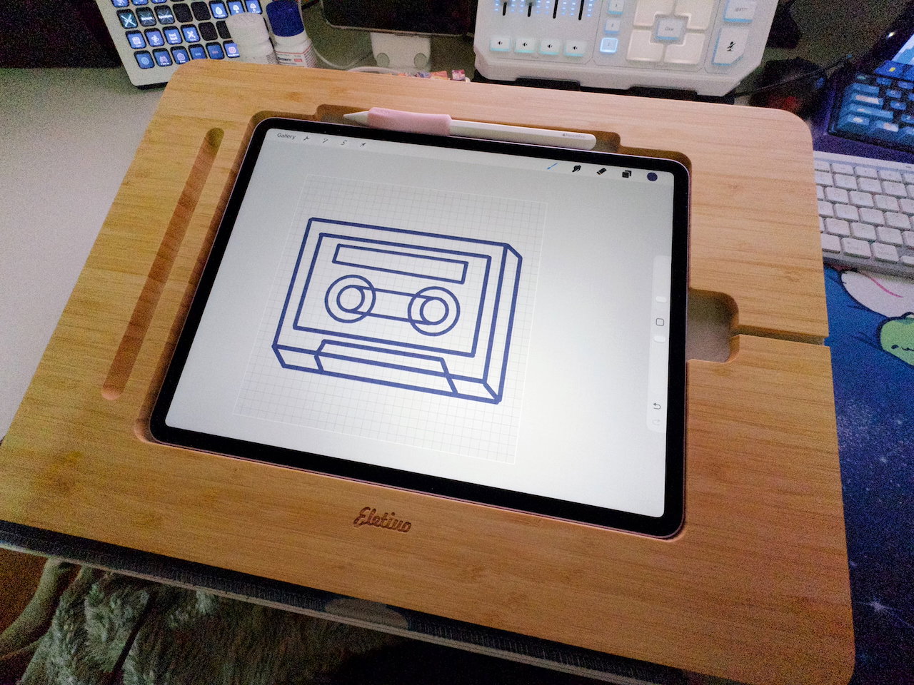 A wooden stand holding an iPad Air 13 inch with Apple Pencil Pro and light pink grip holder.  