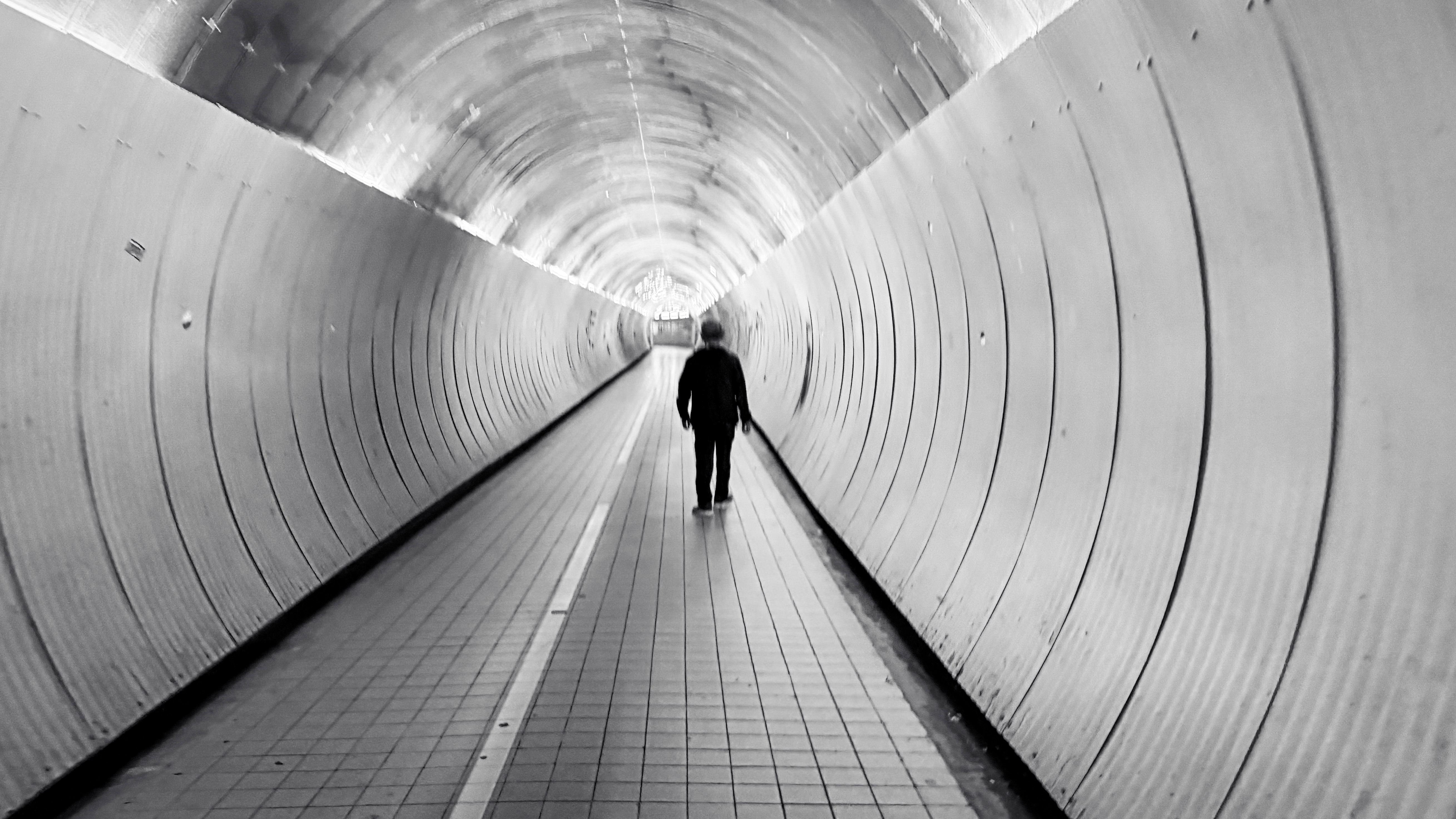 Person walking in a tunnel with bright light