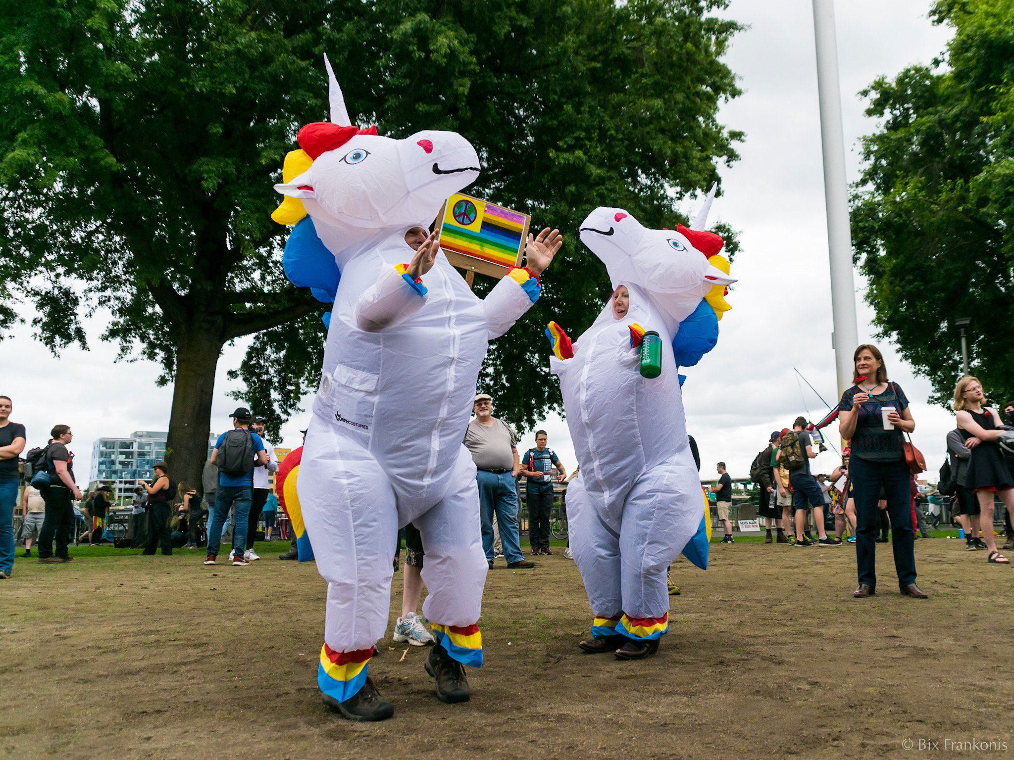 Two people in inflatable unicorn costumes dance