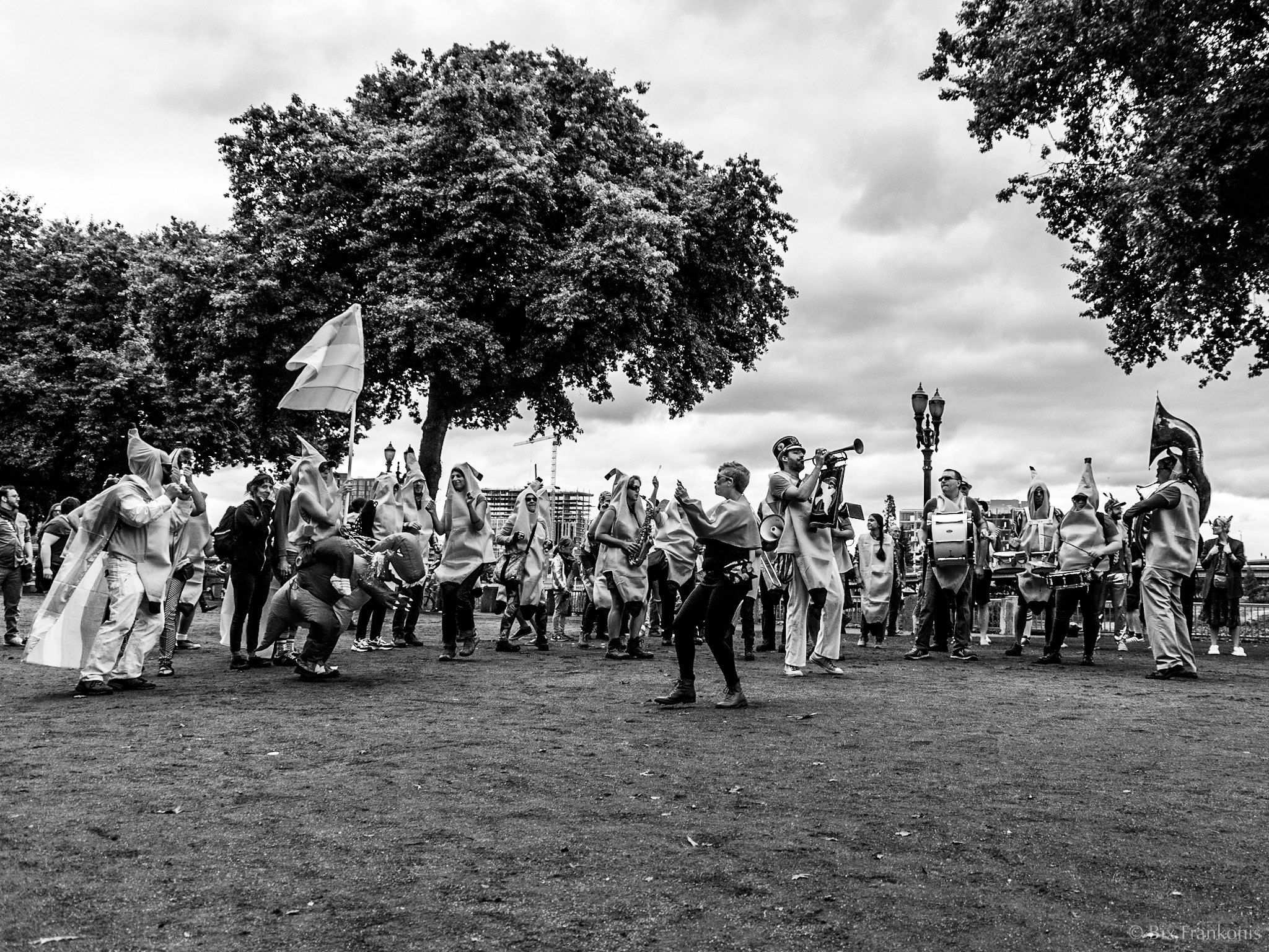 A line of people in banana and other costumes parades while playing instruments