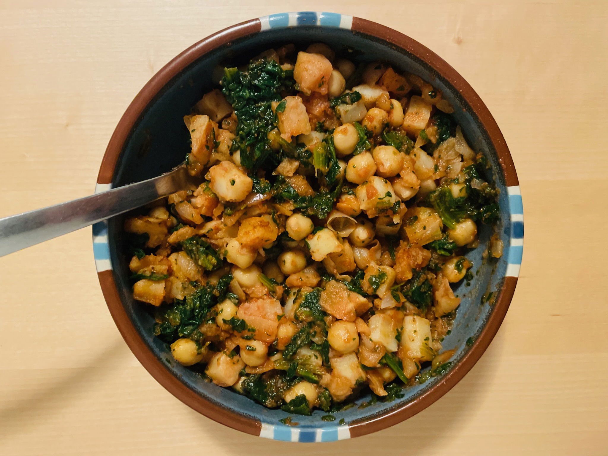 Overhead angle on a blue Dansk Mesa bowl containing a delicious-looking meal, with a fork sticking out of it.
