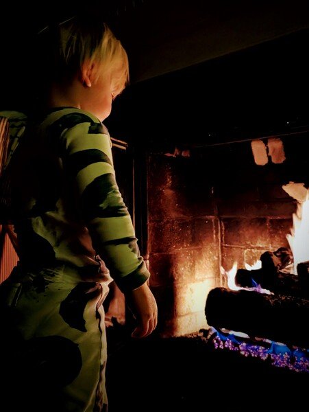 Child gazes, fire glows. Warmth fades into chilly air. Embers die alone.