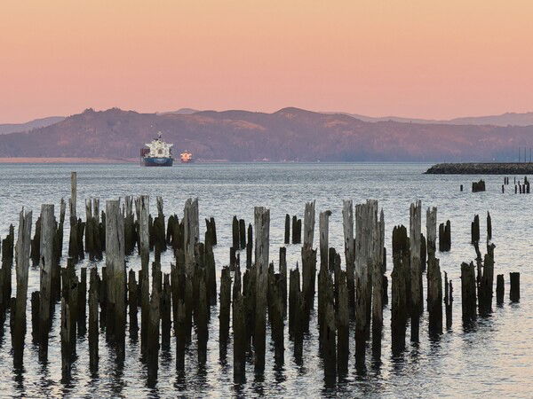 Ships in the Astoria ship channel in the Columbia River with a magificent orange/pink sky, taken from the Riverwalk.