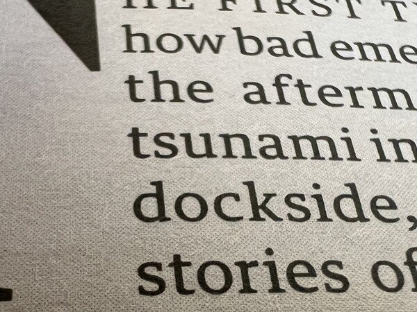 A close up of a page in a supplementary magazine for a newspaper. 

Text on the page, though cut off, reads: “THE FIRST THE [cut] how bad emergency [cut] the aftermath [cut] tsunami in [cut] dockside, [cut] stories of”