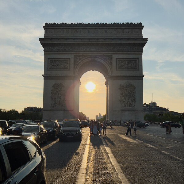 A picture looking straight-on at the Arc de Triumph in Paris, France. The Sun is in the middle of the arch, albeit off-centre.

I would've fixed that in post but my RAW editing skills aren't great and it would've been two obvious.