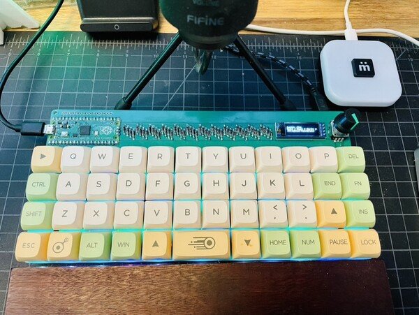 pi40 ortholinear 40% keyboard with green circuit board and yellow/green/white keys on a black desk pad
