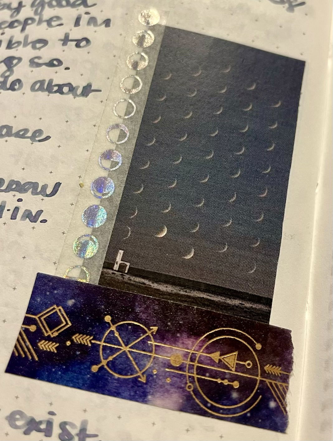 a closeup of a small thumbnail photo of moon phases taped into a journal page with iridescent moon phase washi tape