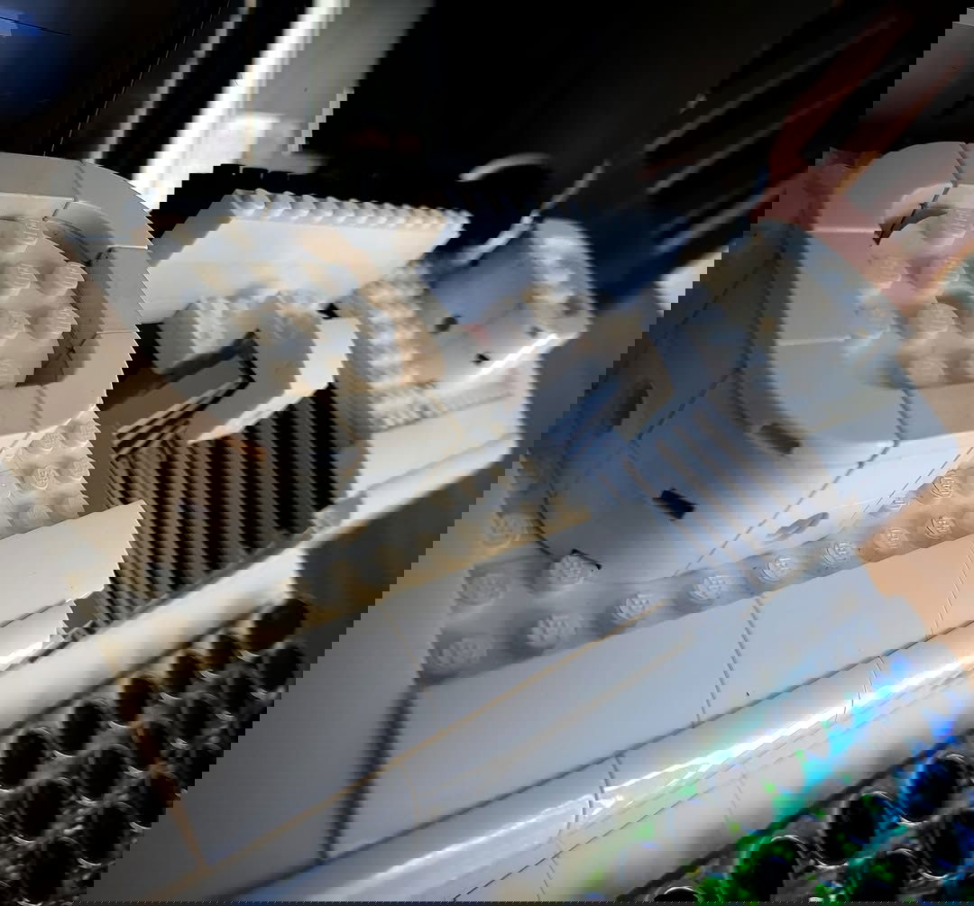 A side-on shot of a white, Lego-built typewriter with an RGB mechanical keyboard for the keys. This time focussing on the rounded square look of the ribbon spools. Up this close you can see some of the blocks are yellowing with age.