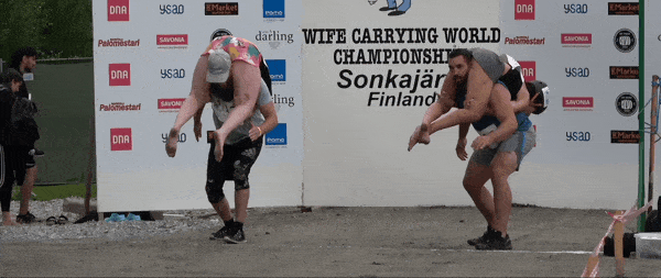 Clip from the 2023 Wife Carrying World Championships video. First obstacle is a water pool, second obstacle is a wooden beam to climb over. 