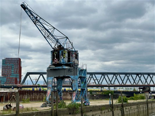 An old port crane, about dilapidated and sprayed everywhere with graffiti, in Hamburg Hafen City.