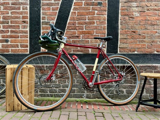 A very, very nice old road bike in front of a brick wall.