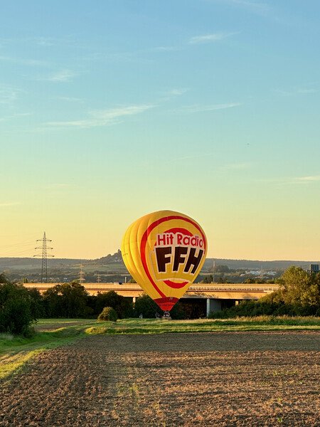 Hot air balloon that just landed on a field.