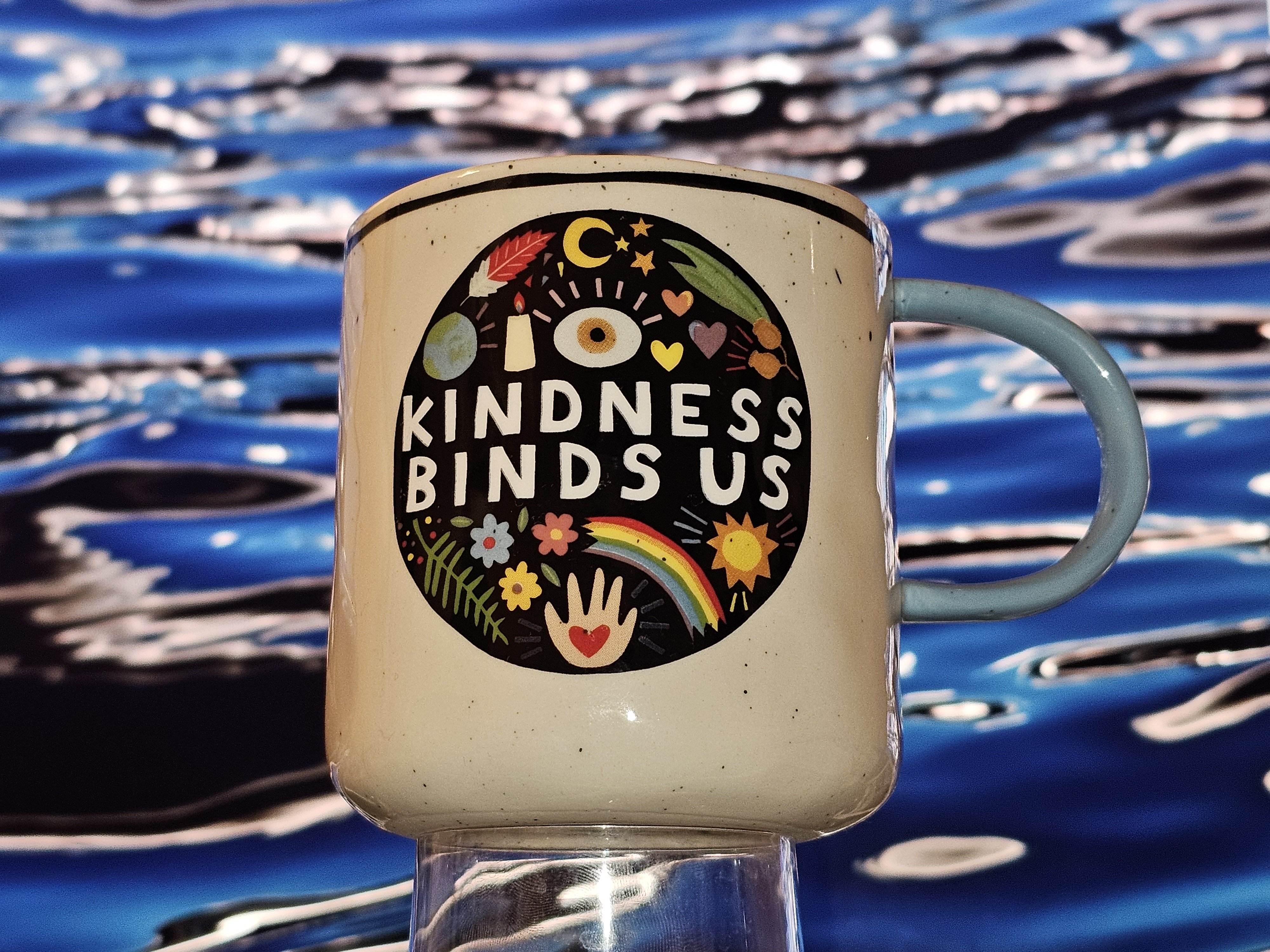 Photograph of a mug which reads 'KINDNESS BINDS US'