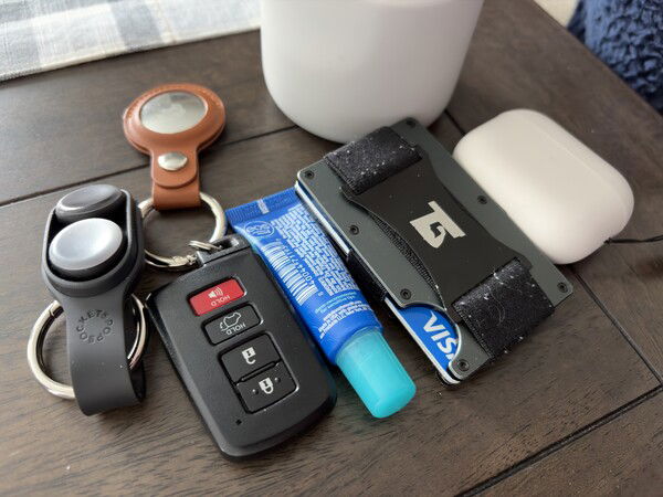 Pocket dump

A wooden table holds a car key fob, lip balm, wallet, earphones, and a leather keychain.