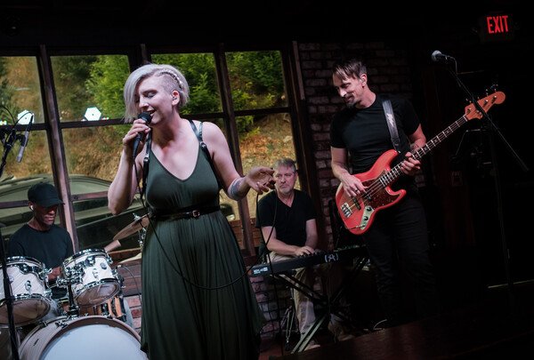 My best friend’s [band](https://gwabn.com) performed their first show with a new lineup last week. They were amazing!

Alt text: A woman with blonde hair wearing a green jumpsuit sings into a microphone. In the background are a drummer, keyboardist, and bassist. 