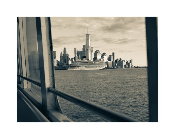 view from a ny ferry looking out at a cruise ship in front of the world trade center. 