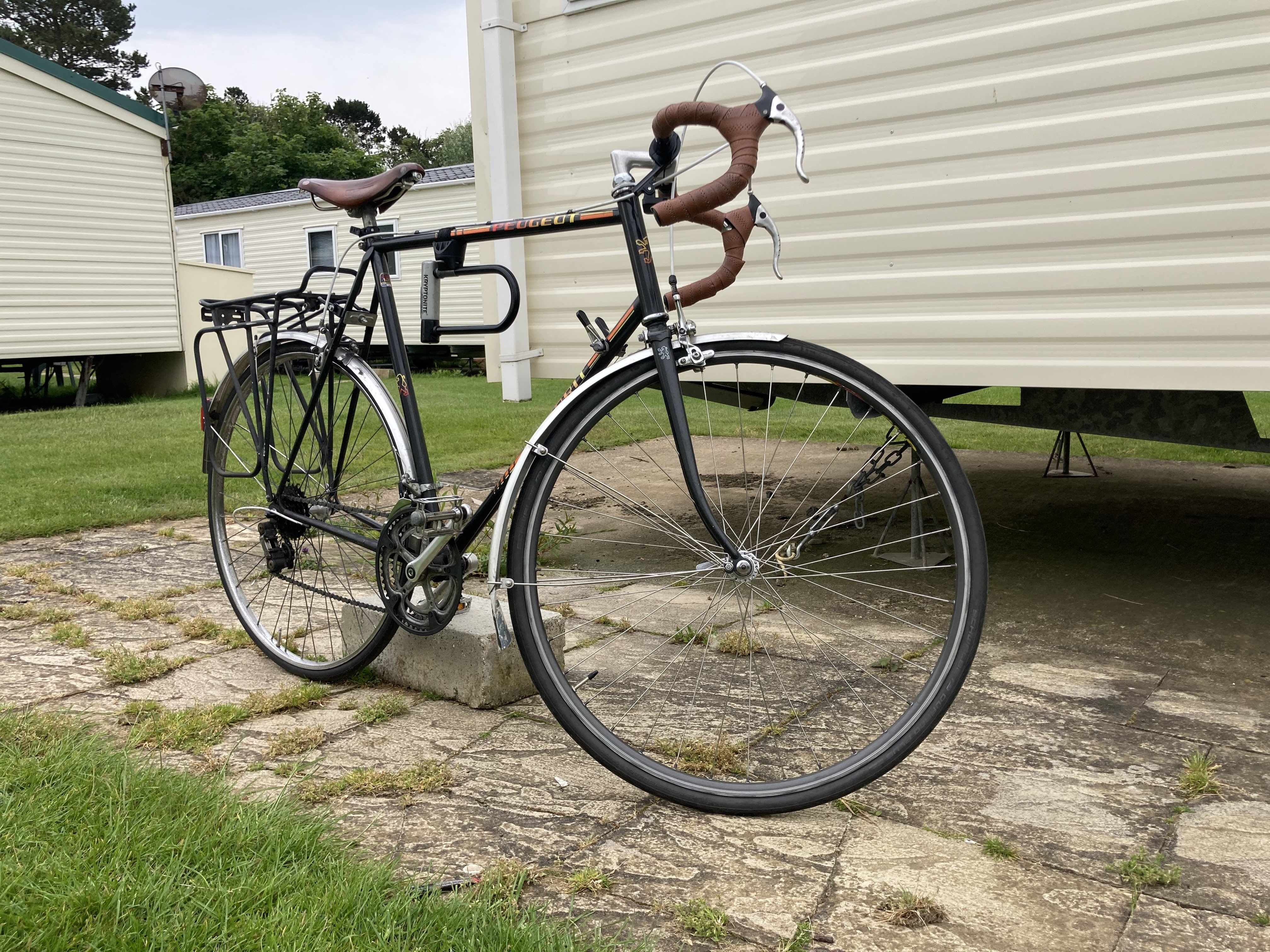 A vintage Peugeot bike, standing majestically in front of some caravans