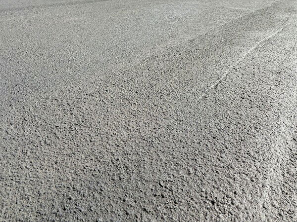 Closeup photo of freshly laid black asphalt on a road.