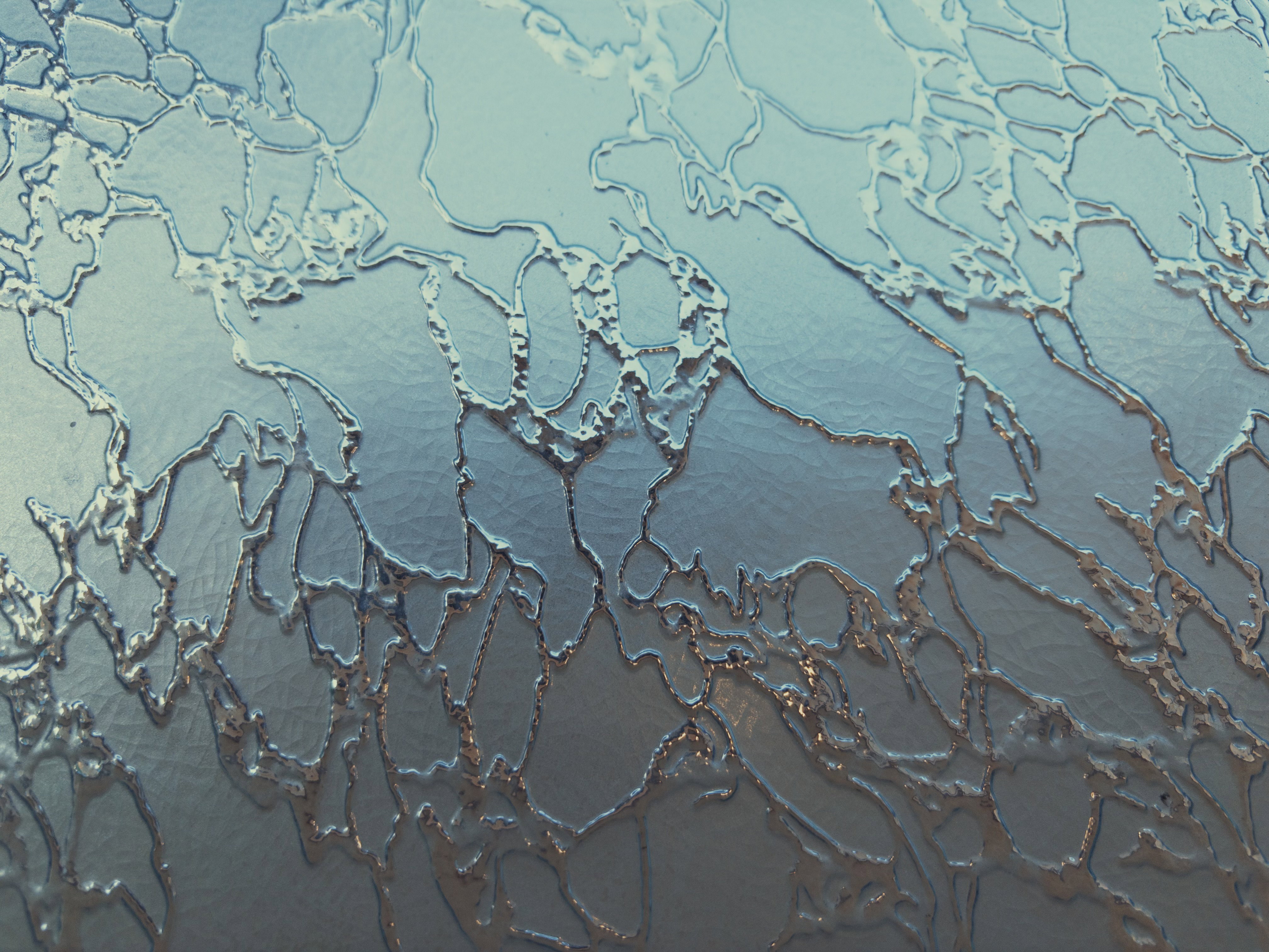Glass textured with a pattern like filled-in cracks.