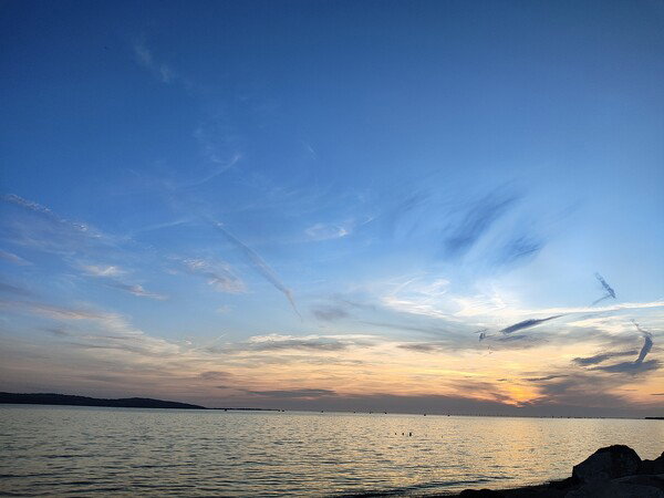 Nautical twilight engulfs the sea and beach.