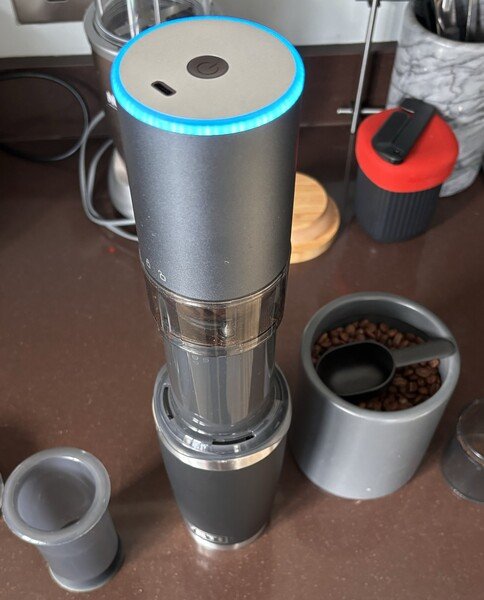 Step two. Showing a coffee cup, AeroPress now topped with an electric burr grinder. It's grinding the whole beans because there's a blue ring shinning on top. 