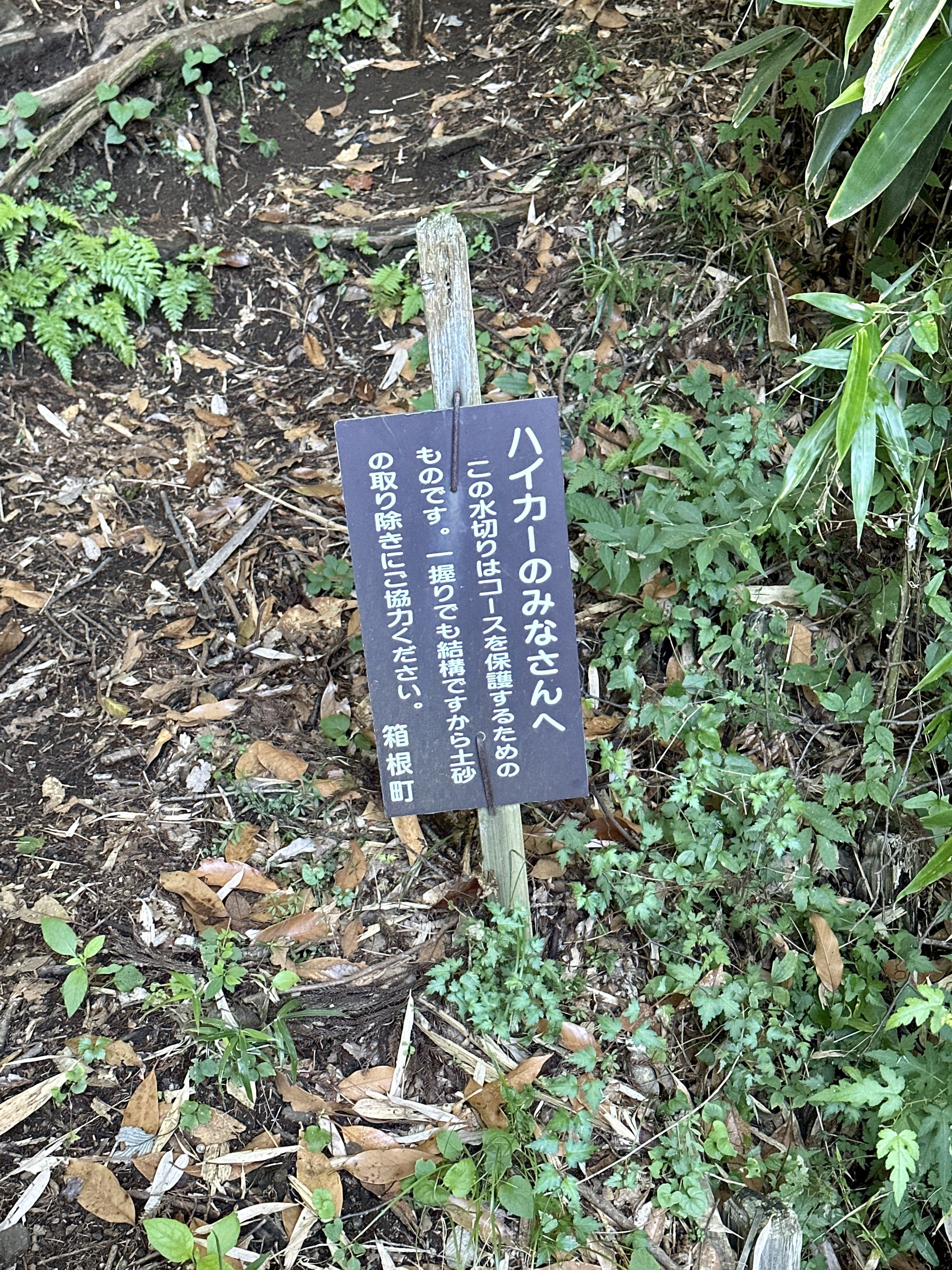 Sign on Hakone hiking trail asking hikers to clear "even one handful" of dirt from the water channels cut across the trail.
