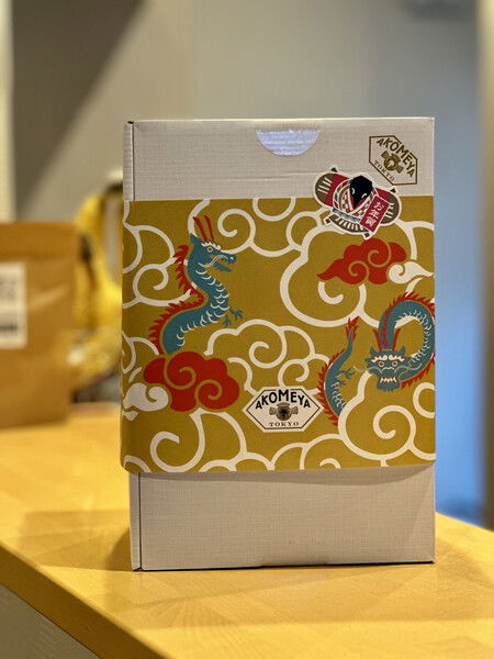 A gold and red dragon-decorated box on a bright indoor table.