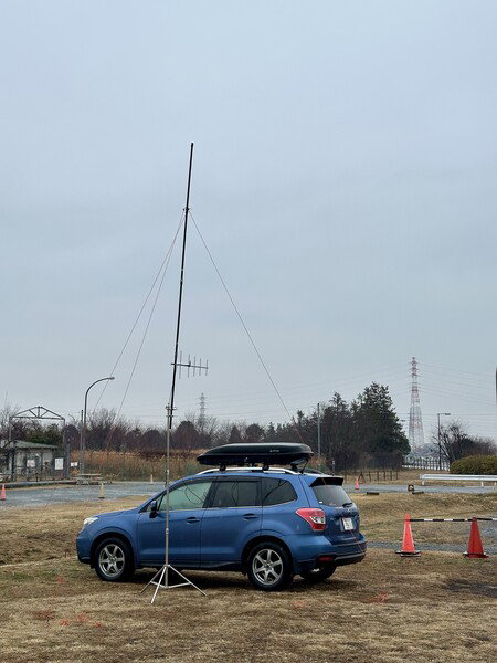 Blue SUV with a portable radio antenna in a park in Kanagawa Prefecture.