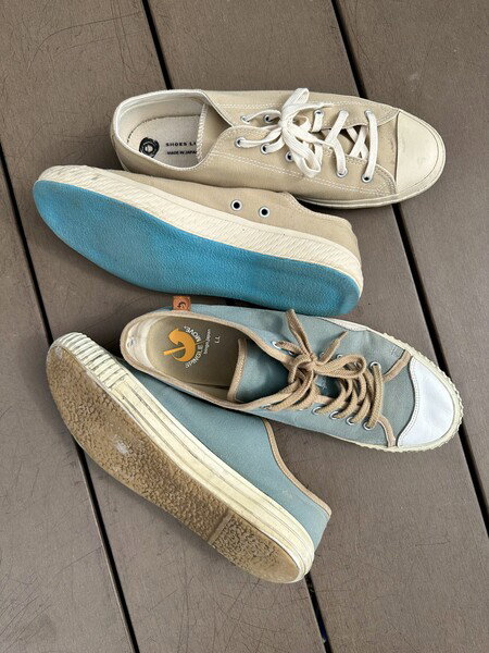 Two pairs of shoes on a wooden deck in an outdoor setting, 戸塚区, Japan.