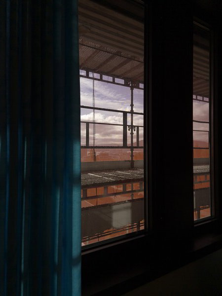Today’s window has the same grubby coating and the same green-and-blue curtains as last time. What’s new is a red filter and the theoretical possibility of building noise
