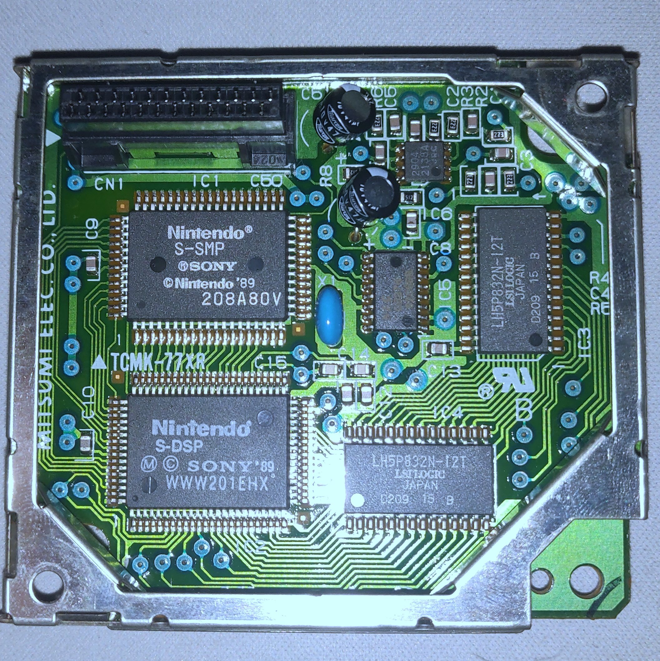 A picture of the SNES APU module. This module appeared on early hardware revisions of the SNES and used a small connector to attach to the main motherboard. Visible are the S-SMP chip, which is a simple 6502-like CPU, and the S-DSP chip, which contains custom silicon for sound generation. Alongside those two are 2 RAM modules and an op-amp for audio output buffering.
