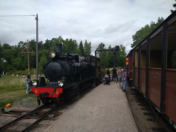 A steam engine refilling water at a stop on the Lenakatten heritage railway line in Uppland, Sweden