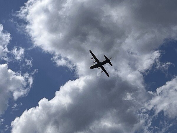 Airplane at air show in partly cloudy sky