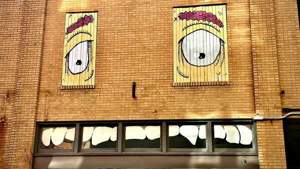 Wandering around Downtown Mobile, looked above a storefront across the street and saw this goofy face painted onto the building using the windows as eyes and a mouth with jagged teeth.