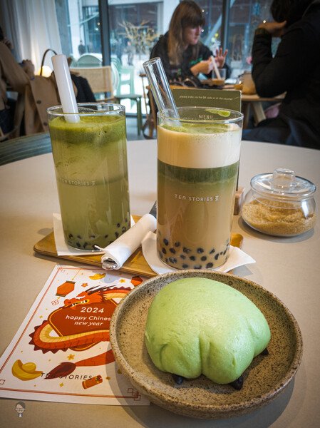 Two big glasses of vegan bubble tea from Good Tea Stories in Eindhoven and one dragon paw bao, with red bean paste filling. Matcha Latte and Matcha Espresso Latte with Tapioca bubbles.