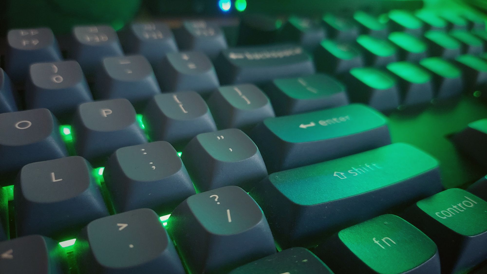 A keyboard Illuminated in neon green.